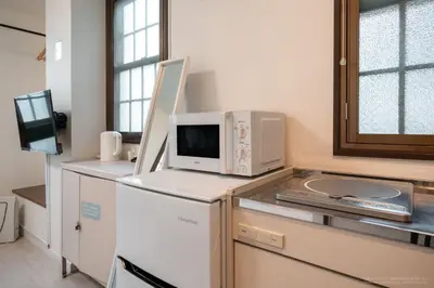 a kitchen with a microwave on top of a refrigerator at 3-40-8 / Vacation STAY 77968 in Tokyo