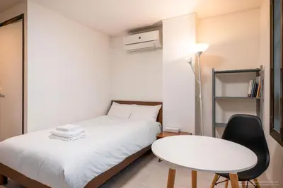 a small bedroom with a white bed and a table at 3-40-8 / Vacation STAY 77968 in Tokyo
