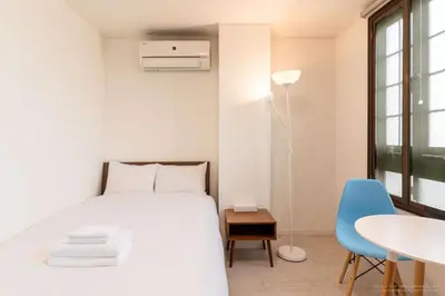 a bedroom with a bed and a table and a blue chair at 3-40-8 / Vacation STAY 77971 in Tokyo