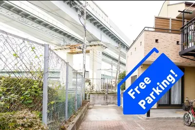 a blue sign that reads free parking in front of a building at QIQA Residence in Tokyo