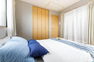 a bedroom with blue pillows on a bed with a window at QIQA Residence in Tokyo