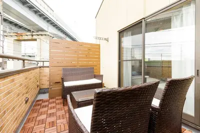 a balcony with two chairs and a table at QIQA Residence in Tokyo