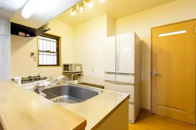 a kitchen with a sink and a refrigerator at QIQA Residence in Tokyo