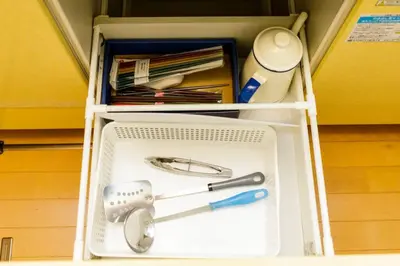 a white cabinet with a drawer with a tool in it at QIQA Residence in Tokyo