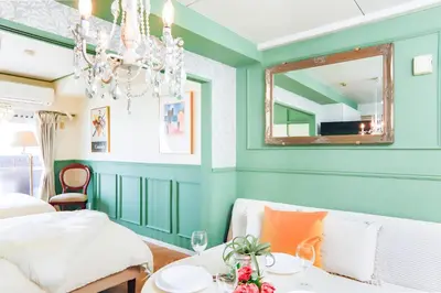 a bedroom with green walls and a chandelier at HARMONIA\u6771\u4eac\u6e0b\u8c37 shibuya in Tokyo