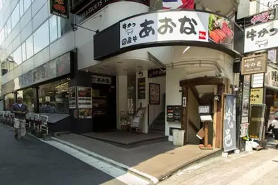 a man walking outside of a building with a store at AZEGAMI 2F in Tokyo