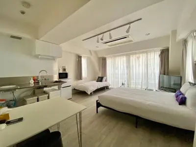a bedroom with a large bed and a kitchen with at CASA VERDE Shinjuku# 1K in Tokyo