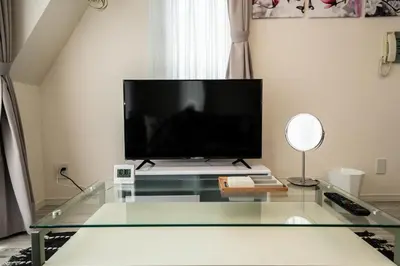 a living room with a tv and a glass table at CASA VERDE Shinjuku# 1K in Tokyo