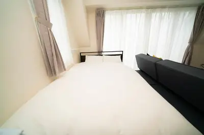 a white bed in a room with a window at CASA VERDE Shinjuku# 1K in Tokyo
