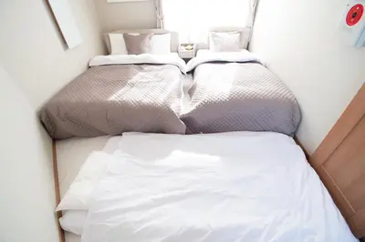 two beds sitting next to each other in a room at Ritz Residence \u58a8\u7530 in Tokyo