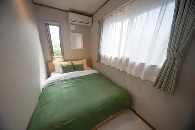a small bed in a small room with a window at Ritz Residence \u58a8\u7530 in Tokyo