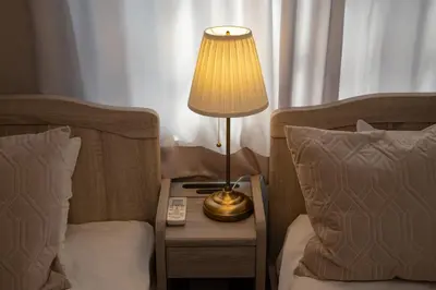 a lamp on a night stand next to two beds at Ritz Residence \u58a8\u7530 in Tokyo