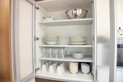 a pantry with plates and dishes on shelves at Ritz Residence \u58a8\u7530 in Tokyo