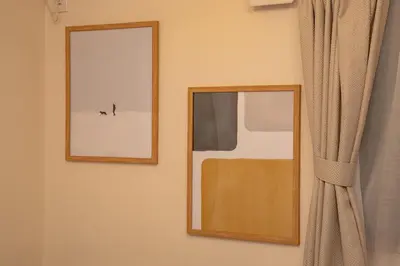 two framed pictures on a wall next to a curtain at Ritz Residence \u58a8\u7530 in Tokyo