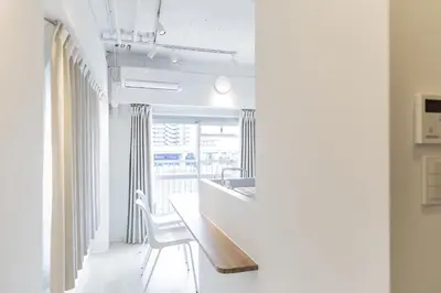 a white kitchen with a table and a chair at Feel Asakusa Stay in Tokyo