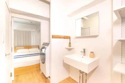 a bathroom with a sink and a bed in a room at Feel Asakusa Stay in Tokyo