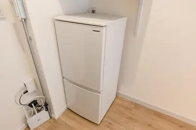 a white refrigerator in a corner of a room at Feel Asakusa Stay in Tokyo