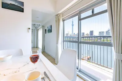 a glass of wine on a table in front of a window at Feel Asakusa Stay in Tokyo
