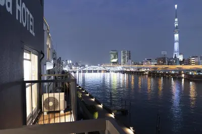 a view of a river with a city at night at Feel Asakusa Stay in Tokyo
