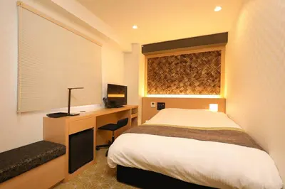 a bedroom with a bed and a desk with a computer at Hotel Matsunoi in Tokyo