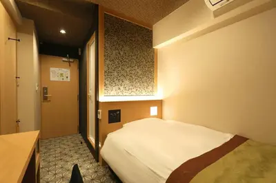 a bedroom with a white bed in a room at Hotel Matsunoi in Tokyo