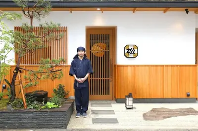 a woman standing in front of a house at Hotel Matsunoi in Tokyo