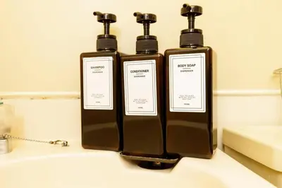 two bottles of soap sitting on top of a sink at Maison d'Orme 503 in Tokyo