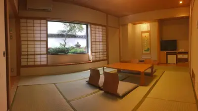 a living room with a table and a window at Hotel Grand Hill Ichigaya in Tokyo