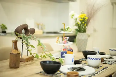 a wooden table with plates and cups on it at \u5bc5\u30db\u30c6\u30eb \u53f0\u6771 Hotel \u5bc5 \u53f0\u4e1c Tora Hotel Taito C in Tokyo