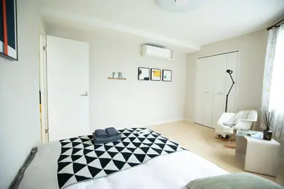 a bedroom with a bed with a black and white blanket at \u5bc5\u30db\u30c6\u30eb \u53f0\u6771 Hotel \u5bc5 \u53f0\u4e1c Tora Hotel Taito C in Tokyo