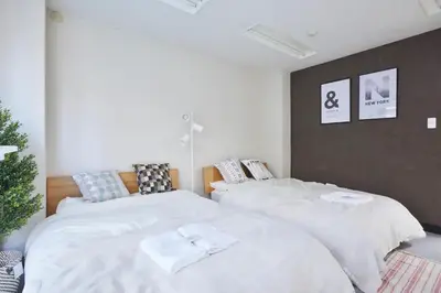 a bedroom with two beds with white sheets at \u5bc5\u30db\u30c6\u30eb \u53f0\u6771 Hotel \u5bc5 \u53f0\u4e1c Tora Hotel Taito A in Tokyo
