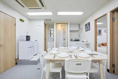a white dining room with a table and white chairs at \u5bc5\u30db\u30c6\u30eb \u53f0\u6771 Hotel \u5bc5 \u53f0\u4e1c Tora Hotel Taito A in Tokyo