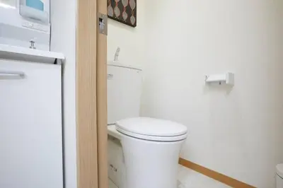 a white bathroom with a toilet and a sink at TORA HOTEL Tokyo-Taito \u5bc5\u30db\u30c6\u30eb\u53f0\u6771B in Tokyo