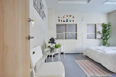 a bedroom with a bed and a table with flowers at TORA HOTEL Tokyo-Taito \u5bc5\u30db\u30c6\u30eb\u53f0\u6771B in Tokyo