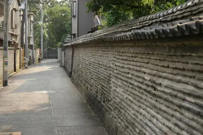 a brick wall with a sidewalk next to a street at TORA HOTEL Tokyo-Taito \u5bc5\u30db\u30c6\u30eb\u53f0\u6771B in Tokyo