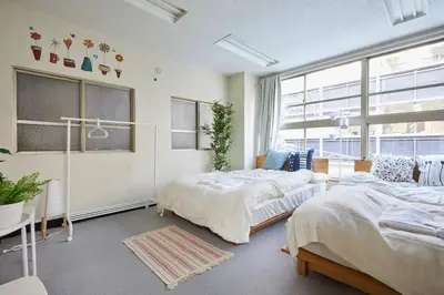 a bedroom with two beds and a window at TORA HOTEL Tokyo-Taito \u5bc5\u30db\u30c6\u30eb\u53f0\u6771B in Tokyo