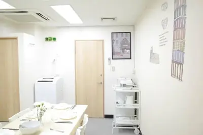 a white room with white tables and a refrigerator at TORA HOTEL Tokyo-Taito \u5bc5\u30db\u30c6\u30eb\u53f0\u6771B in Tokyo
