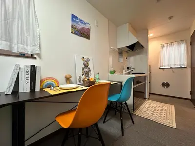 a kitchen with a table and chairs in a room at nestay house tokyo shinjuku in Tokyo