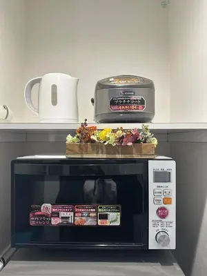 a microwave with a plate of food on top of it at nestay house tokyo shinjuku in Tokyo