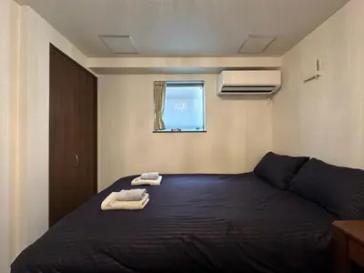 a bedroom with a bed with two towels on it at nestay house tokyo shinjuku in Tokyo
