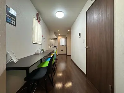 a long room with a long table and chairs at nestay house tokyo shinjuku in Tokyo