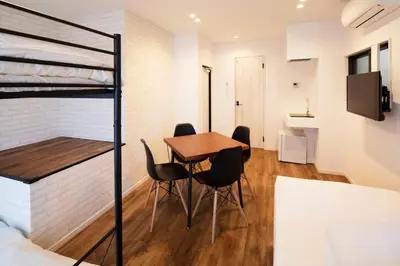 a room with a table and chairs and a bunk bed at HOTEL LITTLE BIRD OKU-ASAKUSA / Vacation STAY 79431 in Tokyo