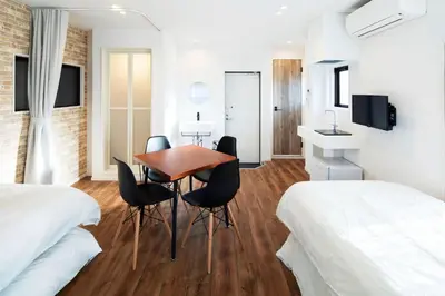 a room with two beds and a table and chairs at HOTEL LITTLE BIRD OKU-ASAKUSA / Vacation STAY 79442 in Tokyo