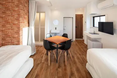 a room with two beds and a table and chairs at HOTEL LITTLE BIRD OKU-ASAKUSA / Vacation STAY 79446 in Tokyo