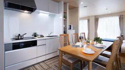 a kitchen and dining room with a wooden table at Minn Kamata in Tokyo
