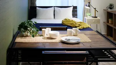 a room with a bed and a wooden table with a table at Minn Kamata in Tokyo