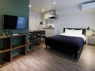 a bedroom with a bed and a desk with a television at Minn Kamata in Tokyo