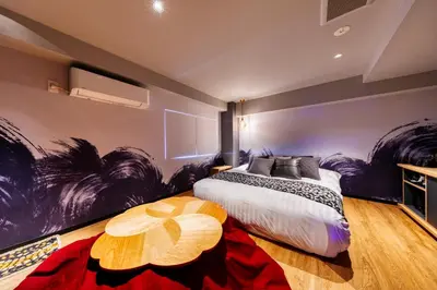 a bedroom with a large bed with a painting on the wall at Hotel Lotus Koiwa (Adult Only) in Tokyo