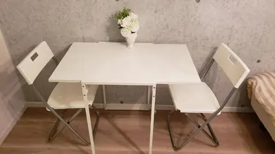 a white table with two chairs and a vase with flowers at Asakusa Sky Stay Tiffany blue Room in Tokyo