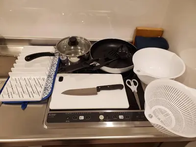a kitchen counter with a stove with a pan and a fan at Asakusa Sky Stay Tiffany blue Room in Tokyo